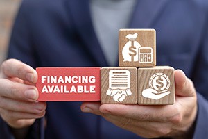 hands holding blocks with financing-related icons on them